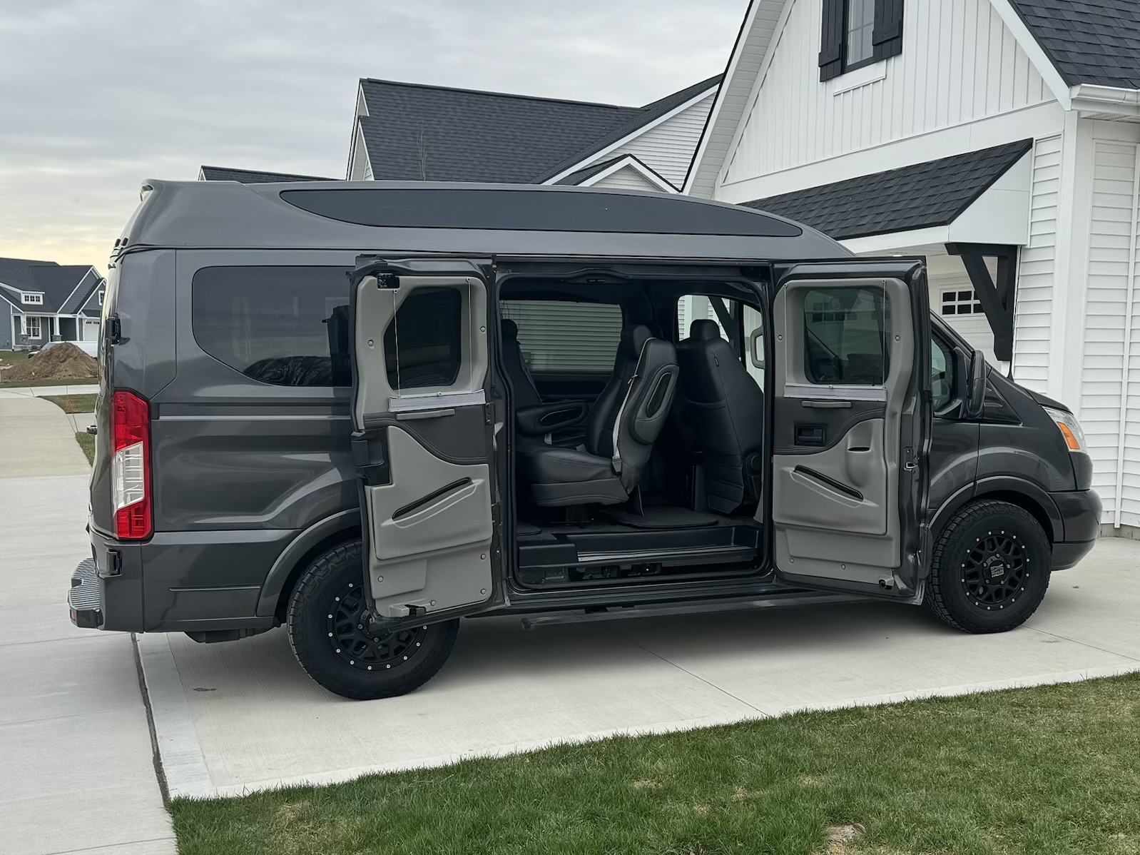 Ford Transit Explorer Van with its side doors open, showing the passenger cabin