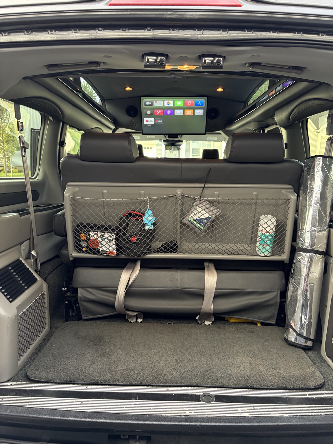 Rear cargo area of the Gig-Van with the 32-inch Smart TV showing streaming apps